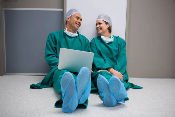 Surgeons using laptop in corridor — Stock Photo, Image