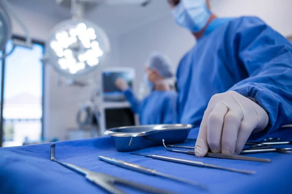 Kirurgen håller kirurgiska verktyg i drift theater — Stockfoto