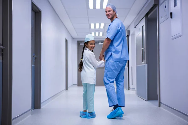 Medico e ragazza a piedi in corridoio — Foto Stock