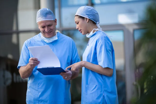 Surgeons discussing over medical reports — Stock Photo, Image