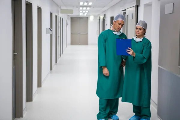 Cirujanos discutiendo informe en portapapeles —  Fotos de Stock