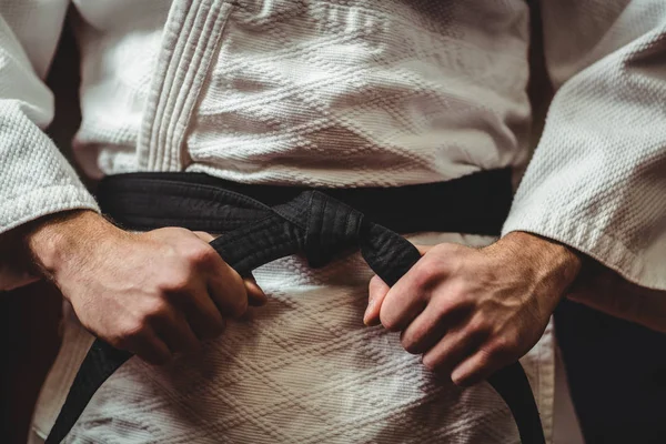 Karate jugador atando su cinturón — Foto de Stock