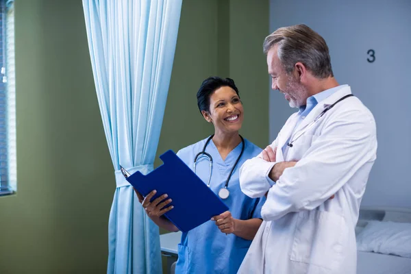 Lekarz i pielęgniarka o dyskusji na plik w oddziale — Zdjęcie stockowe