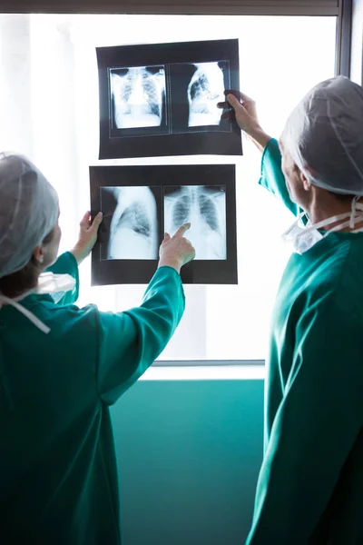 Chirurgiens examinant un rapport de radiographie — Photo