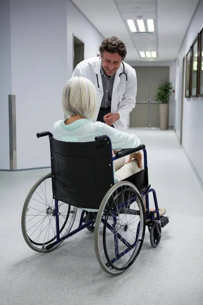 Médico interactuando con el paciente en silla de ruedas —  Fotos de Stock