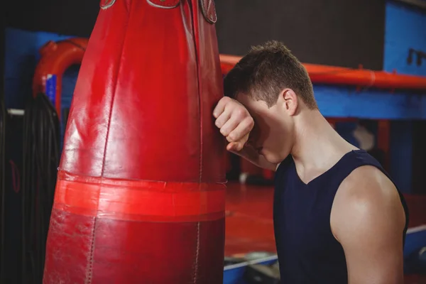 Boxeador deprimido apoyado en el saco de boxeo — Foto de Stock