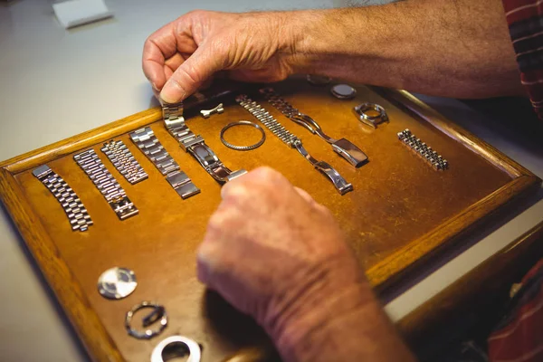 Horólogo organizando pulseira de relógio na placa de madeira — Fotografia de Stock