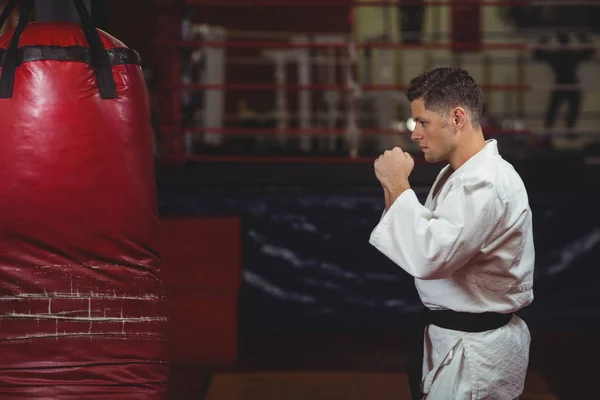 Kum torbası üzerinde pratik karate oyuncu — Stok fotoğraf