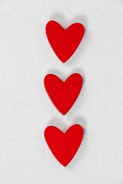 Trzy czerwone serca przechowywane w wierszu — Zdjęcie stockowe