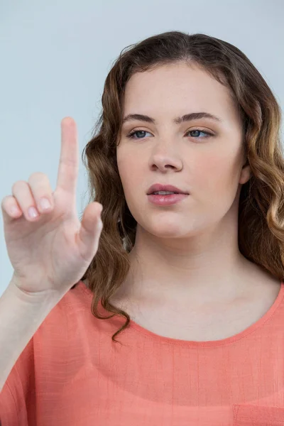 Vrouw voorwenden om een onzichtbare touchscreen — Stockfoto