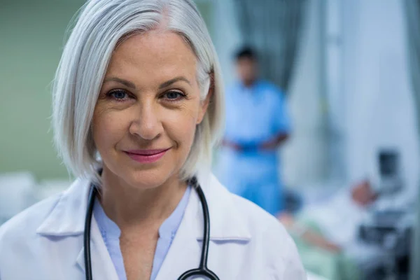 Vrouwelijke arts glimlachend in ward — Stockfoto