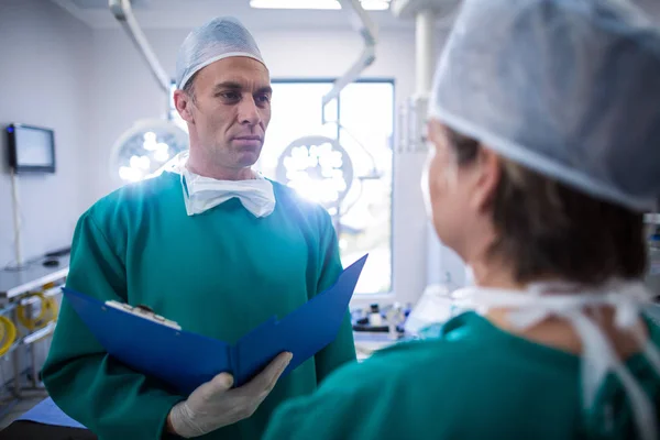 Kirurger interagera i operationssalen — Stockfoto
