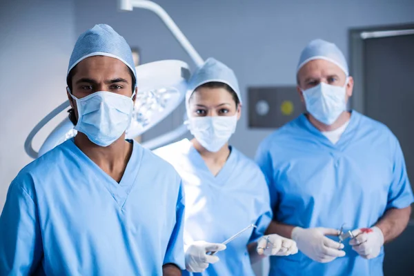 Cirurgiões segurando ferramenta cirúrgica na sala de operação — Fotografia de Stock
