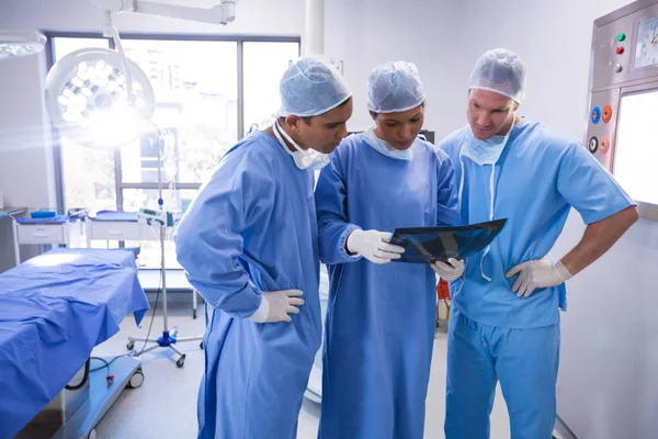 Cirurgiões examinam raio-X na sala de operações — Fotografia de Stock