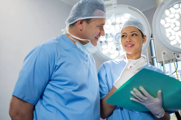 Surgeons discussing over file — Stock Photo, Image