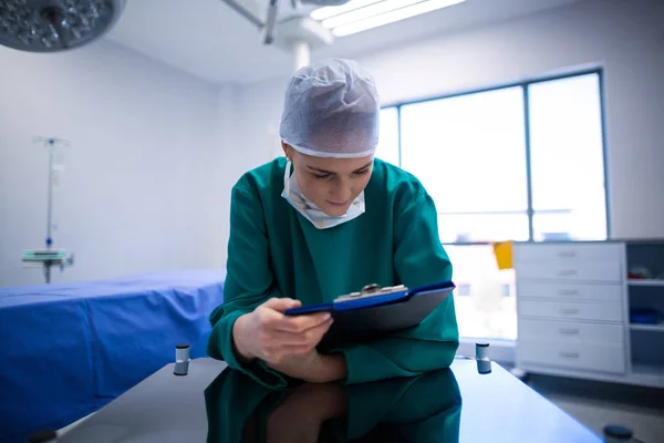 Chirurg kobiece czytanie raportów — Zdjęcie stockowe