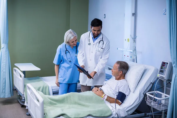 Médico e enfermeiro examinando um paciente — Fotografia de Stock