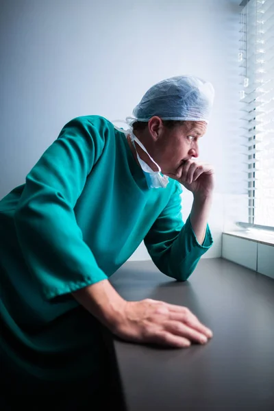 Przemyślane chirurg mężczyzna patrząc przez okno — Zdjęcie stockowe