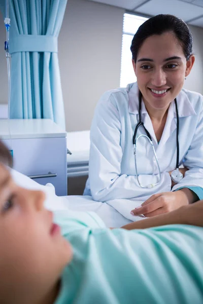 Médico sonriente interactuando con el paciente en la sala — Foto de Stock