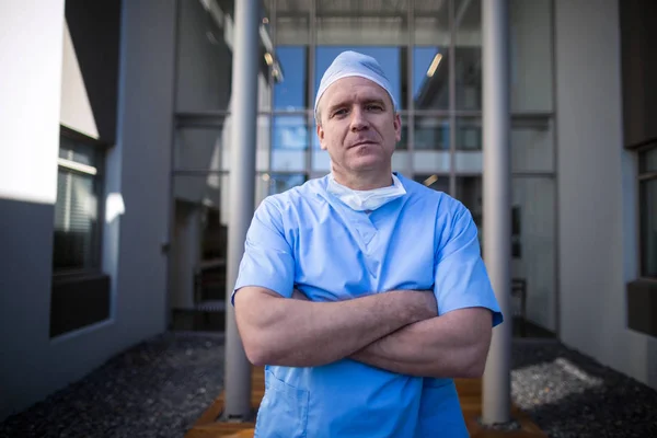 Manliga kirurg står med armarna korsade — Stockfoto