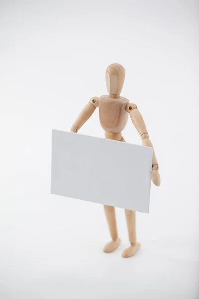 Wooden figurine holding a white placard — Stock Photo, Image