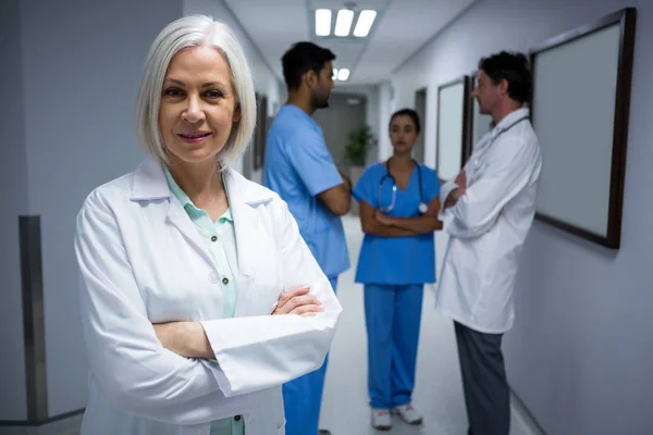 Médico de pie con los brazos cruzados en el pasillo — Foto de Stock