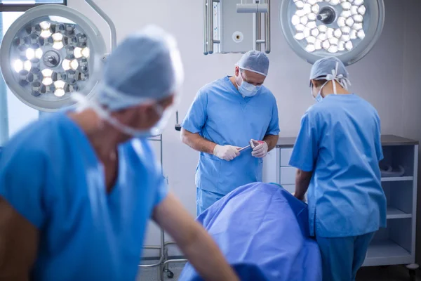 Kirurger som utför åtgärden i operationssalen — Stockfoto