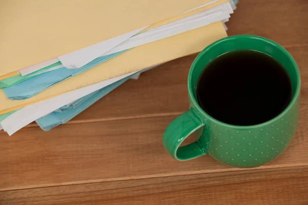 Arquivos e caneca de café na mesa de madeira — Fotografia de Stock