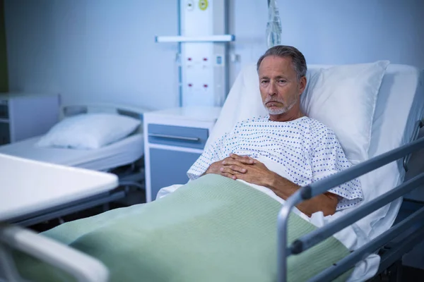 Больной пациент сидит на кровати — стоковое фото