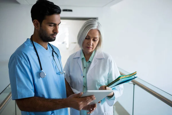 Médecins discutant sur tablette dans le couloir — Photo