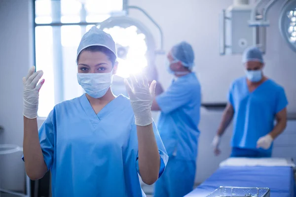 Vrouwelijke chirurg met bloed op chirurgische handschoen — Stockfoto