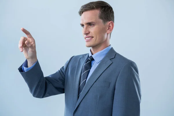 Hombre de negocios sonriente tocando una pantalla invisible — Foto de Stock