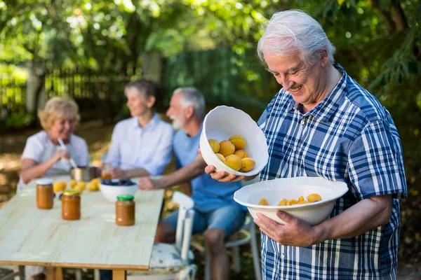 Senior man met een kom van abrikoos in tuin — Stockfoto