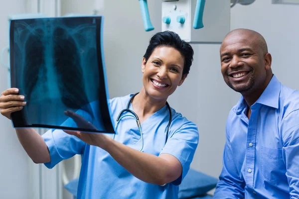 Enfermera y paciente discutiendo rayos X — Foto de Stock