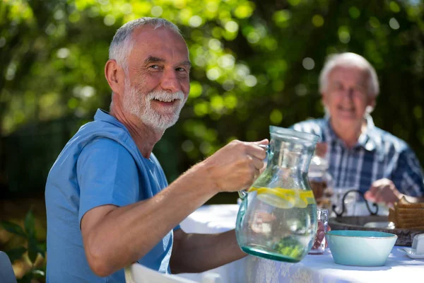 Senior mannen ontbijten in de tuin — Stockfoto