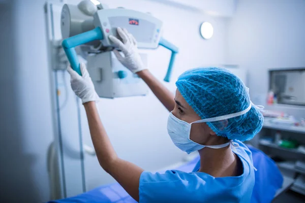 Enfermeira ajustando a máquina de raios-x sobre o paciente — Fotografia de Stock
