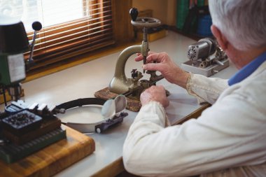 Horologist repairing a watch clipart