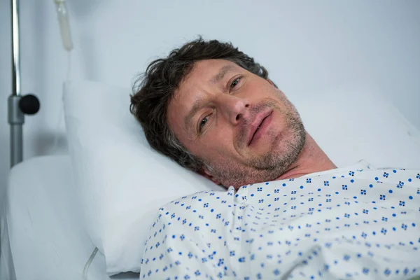 Nemocný pacient ležící na posteli — Stock fotografie