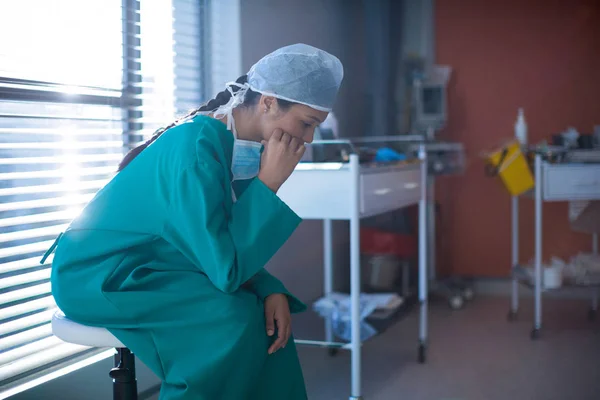 Strnula ženské chirurg sedí v oddělení — Stock fotografie