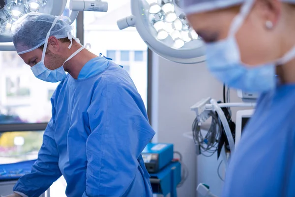 Kvinnliga och manliga kirurg bär kirurgiska mask — Stockfoto