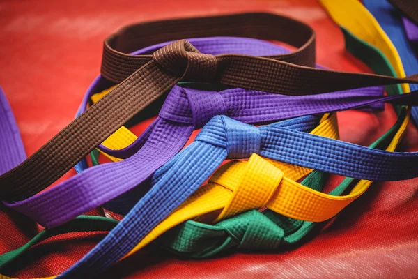 Cinturones de karate multicolores sobre fondo rojo —  Fotos de Stock