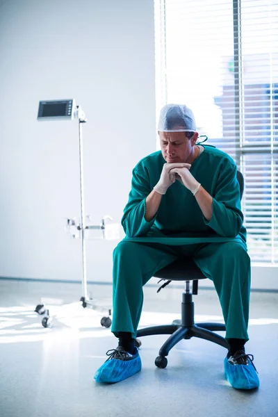 Tensed surgeon sitting on a chair — Stock Photo, Image