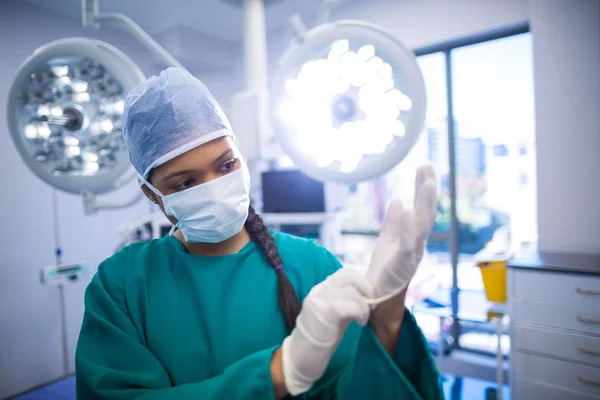 Kirurgen bär kirurgiska handskar — Stockfoto