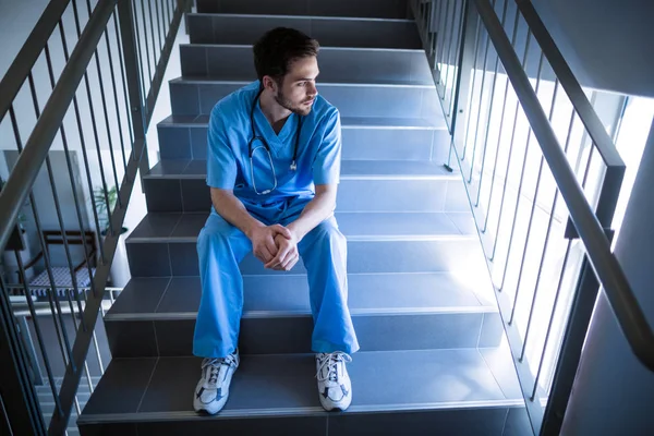 Thoughtful male nurse on staircase — Stock Photo, Image