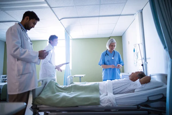 Médico e enfermeiro examinando um paciente — Fotografia de Stock