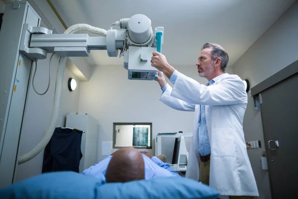 Male doctor sets up the machine to x-ray over patient — Stock Photo, Image