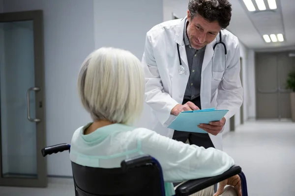Läkare som interagerar med patienten på rullstol — Stockfoto