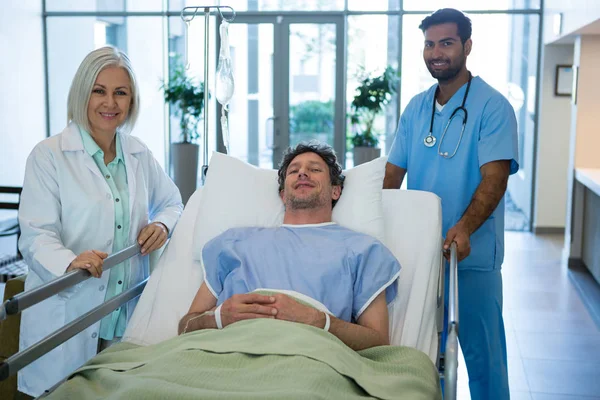 Medici in piedi mentre paziente su barella di emergenza — Foto Stock