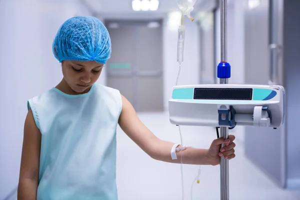 Sad girl standing with iv drip in corridor — Stock Photo, Image