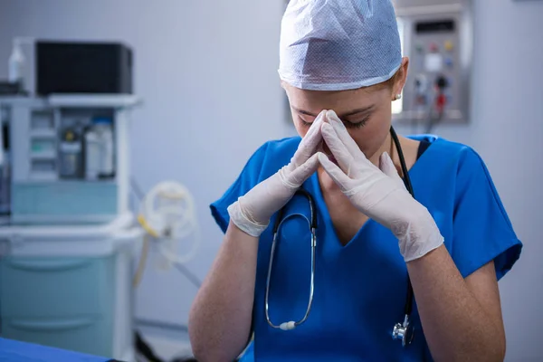 Грустная медсестра, сидящая в операционной — стоковое фото